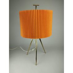 an orange lampshade sitting on top of a table