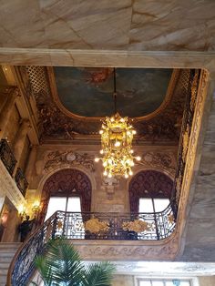 an ornate chandelier hangs from the ceiling in a large room with high ceilings