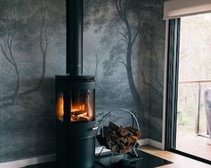 a wood burning stove sitting inside of a living room next to a sliding glass door