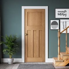 a wooden door in a room next to a stair case