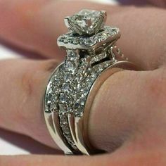 a woman's hand with a diamond ring on her finger and an engagement band