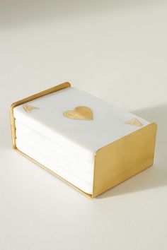 a stack of white and gold coasters with hearts on them