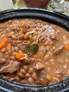 a bowl filled with beans and meat on top of a table