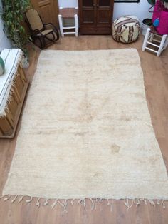 a white rug sitting on top of a hard wood floor next to a wooden dresser