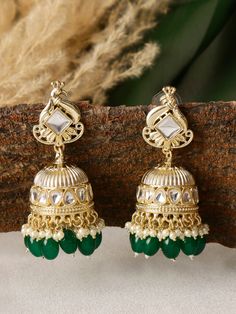 Indulge in the mesmerizing beauty of our Peacock-Shaped Indian Earrings adorned with stunning emerald green pearls. These earrings capture the grace and grandeur of the majestic peacock, a symbol of beauty and abundance in Indian culture, and infuse it with a touch of elegance and enchantment. Crafted with meticulous attention to detail, these earrings showcase the intricate artistry of Indian jewelry-making. The peacock motif, delicately carved with precision, embodies the rich cultural heritage and artistic legacy of India. The radiant emerald green pearls, reminiscent of lush landscapes, accentuate the beauty of these earrings, creating a captivating and harmonious color palette. Wear these earrings with pride and confidence, as they effortlessly become the centerpiece of any ensemble. Green Jhumkas For Wedding And Eid, Traditional Green Jhumkas For Wedding, Emerald Earrings For Wedding And Festivals, Green Bridal Earrings For Wedding, Green Peacock Jhumkas For Diwali, Green Peacock Design Jhumkas For Diwali, Bollywood Style Green Peacock Jhumkas, Diwali Green Jhumkas With Peacock Design, Green Cutdana Jhumkas For Celebration