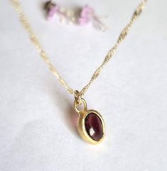 "Beautiful solid gold pendant necklace with an oval red garnet, minimalist jewelry for women in 9k or 14k solid yellow gold. This regal necklace is solid gold and has an oval solid gold pendant. The pendant is set with an oval garnet with a deep red color. It is available in 9k or 14k solid yellow gold in 16\" or 18\" lengths. This necklace is simply breathtaking. It is delicate and romantic yet striking and meaningful. You can wear it as a single item or layered with other necklaces for a total boho-chic look. It will accompany you for many years to come. Don't hesitate to order this fabulous necklace and enrich your look with this romantic piece. Item details: 1 solid gold pendant necklace. Dimensions: Pendant size: 0.4\"x0.3\" (9.5mmX7.5mm). Gemstone size: 0.23\"x0.31\" (6mmX8mm). Neckl Elegant 14k Gold Birthstone Necklace With Oval Pendant, Yellow Gold Garnet Necklaces With Oval Shape, Yellow Gold Oval Garnet Necklace, 14k Gold Birthstone Oval Pendant Necklace, Gold Oval Garnet Necklaces, 14k Gold Gemstone Oval Pendant Necklace, Oval Gold Birthstone Necklace In 14k Gold, Gold Oval Birthstone Necklace, Oval Garnet Gold Necklace