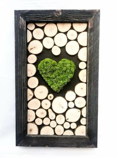 a wooden frame with a heart made out of wood slices and moss in the center