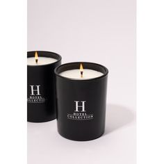 two black candles sitting next to each other on a white surface with the words hotel collection