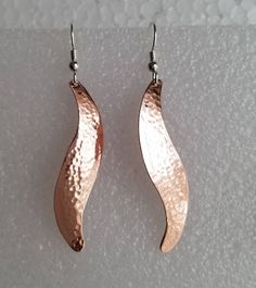 Hammered copper earrings with sterling silver ear wires. These are just one of the many hammered earring shapes that I have listed in my shop. They are available in 2 sizes, medium,2&1/4 inches long including the ear wires, and large, 2&3/4 inches long including the ear wires. The manikin in the photo is smaller than life size. My hammering technique domes them slightly and hardens the metal a little so they hold their shape. They are also available smooth and shiny, not hammered which I Rose Gold Hammered Dangle Earrings, Hammered Copper Drop Earrings, Copper Dangle Earrings With French Hook, Hammered Rose Gold Copper Earrings, Rose Gold Hammered Metal Earrings, Earring Shapes, Hammered Copper Earrings, Silver Clay, Hammered Copper