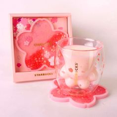 a pink bear candle holder next to a starbuck's cup in a box