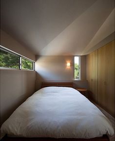 a bed sitting under a window in a bedroom