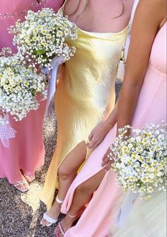 bridesmaids in pastel dresses holding bouquets of baby's breath