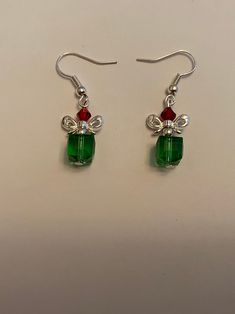 This is a pair of handmade silvertone dangle earrings for Christmas.  There is a red glass bead, a green glass bead, and a metal bow.  The ear wires are silver plated.  Thank you for your interest! Red Ear Wire Jewelry For Holidays, Beaded Dangle Christmas Jewelry, Christmas Beaded Dangle Jewelry, Christmas Jewelry Gift With Matching Earrings, Christmas Jewelry Gift Set With Matching Earrings, Beaded Jewelry Christmas Gift, Christmas Beaded Jewelry Gift, Christmas Jewelry Set As Gift With Matching Earrings, Beaded Jewelry For Christmas Gift