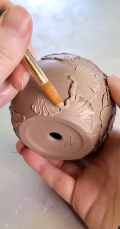 someone is painting the inside of an egg with a paintbrush in their left hand