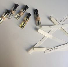 five small bottles are lined up next to each other on a white surface with labels