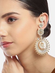 These gorgeous off-white flower-shaped multi-layer earrings come with kundan stone studs & beads, are gold-plated, have an integrated ear chain and secured with a post and back closure. These unique handcrafted jhumkas can be styled with any traditional outfit, or an evening outfit to add that Wow! factor. Product color may vary based on the monitor or screen you are using.See FAQ for more details. Size Length of earring: 8.5 cmLength of ear chain: 13 cm Details Material: BrassStones: Kundan & A Gold Chandelier Earrings With Stone Work, Gold Fusion Chandelier Earrings With Stone Work, White Gold Plated Earrings For Diwali, White Fusion Danglers With Latkans, Gold Plated White Earrings With Latkans, White Earrings With Gota Work For Celebrations, White Bollywood Earrings With Gota Work, White Chandbali Earrings With Gota Work, Festive Fusion Style White Danglers