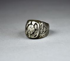 "Antique Berber solid silver ring finely decorated with engraved waving-shaped motifs on the front and on both sides. The front side of the ring measures 0.74 X 0.62 inches (19 X 16 mm), and the inner diameter of the ring measures 0.78 inches (20 mm). Beautiful antique patina of the silver. Provenience: Essaouira, Morocco. Weight: 24.7 g. Ring size (US): 10 1/4 Back to \"Rings\" section: https://www.etsy.com/shop/ArteOrientaleBologna?ref=hdr_shop_menu%C2%A7ion_id%C2%A7ion_id&section_id=18844837 Ornate Ceremonial Engraved Rings, Ornate Engraved Ring For Ceremonial Occasions, Silver Antique Stamped Rings, Antique Silver Engraved Ring, Ornate Silver Engraved Ring Hallmarked, Ornate Silver Engraved Ring With Hallmark, Silver Symbolic Engraved Carved Ring, Antique Silver Engraved Hallmarked Ring, Antique Silver Stamped Signet Ring