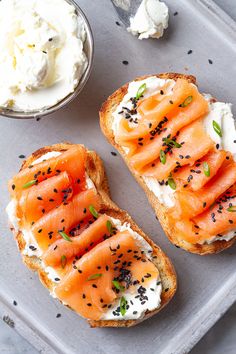 two pieces of bread with cream cheese and salmon on them