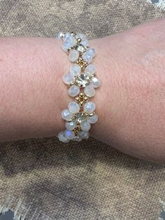 a close up of a person's arm wearing a bracelet with stones on it