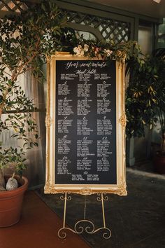 a sign that is sitting in front of a potted plant with flowers on it