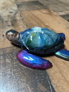 a glass turtle sitting on top of a wooden table