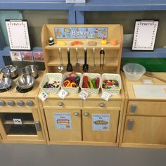 a wooden toy kitchen with lots of cooking utensils