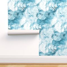 a wallpaper with blue and white flowers on it, next to a wooden floor