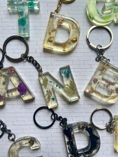 the letters are made out of glass and have different designs on them, as well as key chains