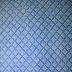 an up close view of a blue and white quilted material with diamond design on it