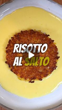 a white plate topped with yellow sauce and an inscription that reads risotto al salto