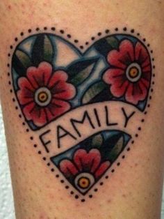 a heart tattoo with flowers and the word family on it's side, is shown