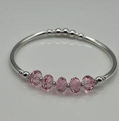 Pink crystal and sterling silver plated elastic bangle bracelet that is so easy to put on and off! This piece is designed using exquisite faceted pink Austrian Crystal rondelles, sterling silver plated beads and sterling silver plated tube beads.  This elegant bangle will look beautiful alone or stacked with your other bracelets.  A wonderful bridesmaid gift. More colors will be coming soon!!  As always our pieces are nickel and lead free and will arrive in a cotton lined gift box tied with a satin ribbon. Hypoallergenic Silver Stretch Bangle Bracelet, Silver Adjustable Crystal Bracelet For Friendship, Silver Jubilee Stretch Bracelet As Gift, Adjustable Sterling Silver Stretch Bracelet Gift, Adjustable Silver Faceted Stretch Bracelet, Adjustable Silver Stretch Bracelet With Faceted Details, Silver Adjustable Faceted Stretch Bracelet, Adjustable Silver Crystal Bracelet Hypoallergenic, Silver Stackable Stretch Bracelet As Gift