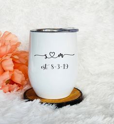 a white coffee mug with the word mr and mrs on it next to an orange flower