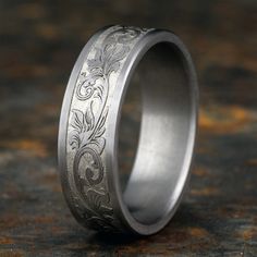 Dynamic filigree patterns are carved along the top of this handsome men's 7.0mm wedding band, fashioned in bold tantalum. The band features Comfort-Fit, which gives a narrower feel than it's actual width when worn. Comfort-Fit rings are designed to have a slightly rounded inside surface so less of the metal touches your finger, which enhances the feel of the ring while wearing and sliding it on and off your finger. Engraved Titanium Wedding Jewelry, Engraved Titanium Jewelry For Weddings, Wedding Engraved Titanium Jewelry, Classic Titanium Jewelry For Wedding, Classic Titanium Wedding Jewelry, Filigree Wedding Band, Filigree Pattern, Jared The Galleria Of Jewelry, Size 10 Rings