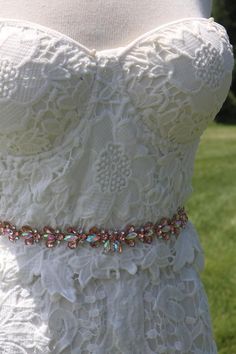 a white wedding dress on display in the grass