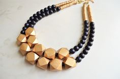 A beaded multi strand statement necklace made with black and gold wood beads. The necklace is light weight.- 2 strands - Big gold bead size is .75" - Shortest strand 20.5-22.5" (length can be customized)- Clasp is gold stainless steel and (gold filled, stainless steel or sterling silver clasps are also available) - Connector is lead free pewter The mannequin's neck size is 15". The necklace can be made with more/less strands. Larger quantities may be available. All DLD jewelry comes in a silver Chunky Bead Necklace, Large Bead Necklace, Beaded Jewelry Earrings, Blue Statement Necklace, Chunky Bead Necklaces, Silver Jewelry Box, Nice Jewelry, Necklace Ideas, Wood Bead Necklace