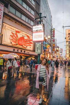 a woman is walking down the street in the rain with an umbrella over her head