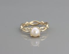 a gold ring with a white pearl in the middle