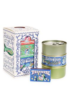 two tins of candles are sitting next to each other on a white surface, one is green and the other is blue