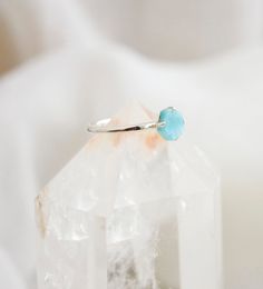 This petite yet dazzling ring, made of sterling silver, displays a beautiful slice of genuine Larimar. Regardless of your personal style, every gem boasts their own individual shape, making them just as exceptional as you. Each stone ranges in a mix of aqua blue and white. Larimar Meaning: Exclusive to the Dominican Republic, Larimar is a rare blue form of Pectolite. The man who coined the name Larimar, named it after his daughter, taking part of her name (Larissa) and the Spanish word for sea ( Turquoise Larimar Ring As Gift, Turquoise Larimar Ring For Gift, Sterling Silver Jewelry With Blue Raw Stone, Blue Sterling Silver Jewelry With Raw Stone, Blue Larimar Opal Ring, Turquoise Crystal Gemstone Ring In Sterling Silver, Blue Natural Stone Crystal Ring In Sterling Silver, Larimar Turquoise Ring Gemstone Gift, Turquoise Larimar Ring Gift