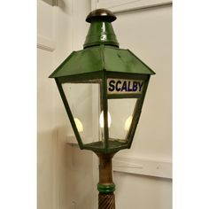 an old fashioned green street light with scalby written on the front and side