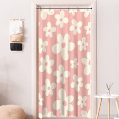 a pink and white shower curtain with flowers on it in a bathroom next to a chair