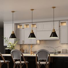 a kitchen with white cabinets and black counter tops, three chairs are in front of the bar