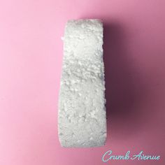 a piece of white toilet paper sitting on top of a pink surface