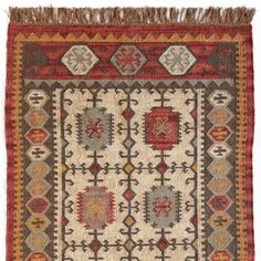 an antique afghan rug with geometric designs and fringes on the bottom, in brown, red