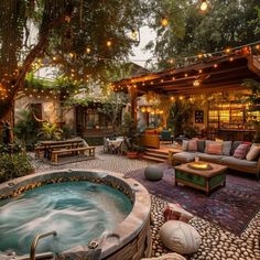 an outdoor hot tub in the middle of a patio with seating and lights strung over it