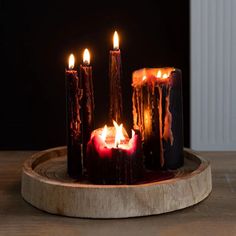 several lit candles sitting on top of a wooden tray