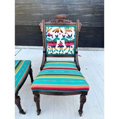 an old chair and foot stool are decorated with colorful fabric