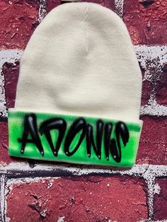 Custom made beanie with airbrush name desing. all beanies are unique since they are all free-hand airbrush painted. all beanies will look sligthly different, no beanies are identical please provide the following: - one word or name - choice one or two colors for background    thank you for choosing us for your custom garments. Beanie Hat Custom, Handmade Multicolor Acrylic Beanie, Airbrush Trucker Hat, Multicolor Acrylic Beanie, One Size Fits Most, Multicolor Acrylic Beanie, One Size, Air Brush Painting, Skull Cap Beanie, Bat Mitzvah, Skull Cap