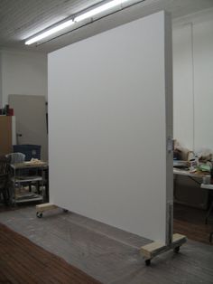 an empty room with a large white board on the floor